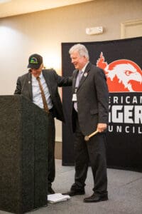 Two men on stage at a podium.