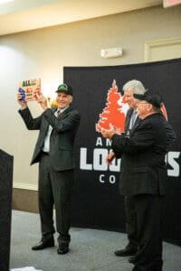 Three men celebrating at an awards ceremony.