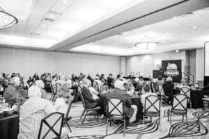Audience attending loggers' conference in a hall.