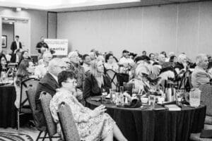 Audience attending a conference in black and white.