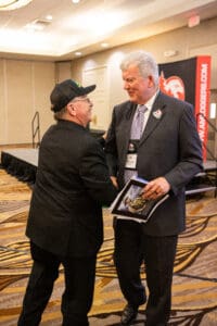 Two men shaking hands at an event.