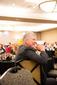 Man smiling at business event audience.