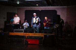 Band performing on stage with instruments.