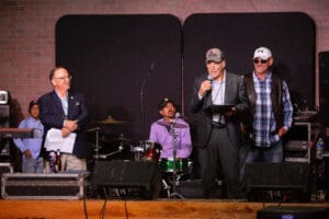 Group of men on stage with microphones.