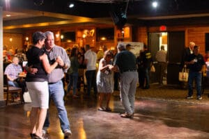 Couples dancing at a lively indoor event.