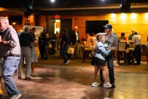 Couple dancing in a lively indoor gathering.