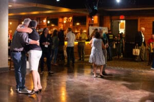 Couples dancing in a dimly lit room.