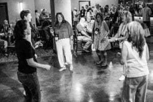 People dancing at a social gathering, smiling.