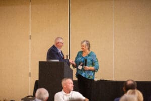 Man and woman shaking hands at event.