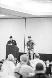 Two men speaking at a conference.