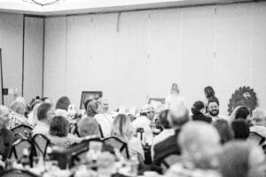 Crowded banquet hall with people seated.