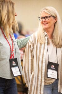 Two women at a conference event talking.