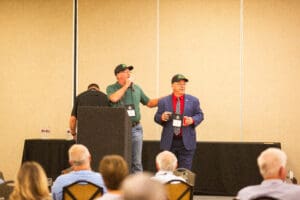 Two men speaking at a conference podium.