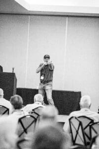 Man speaking to audience at conference.