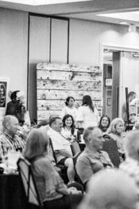 People at indoor event, black and white.