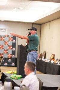 Man speaking at indoor event podium.