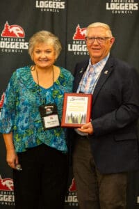 Two people posing with an award plaque.