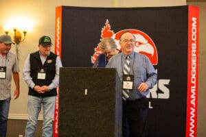 People at an event podium with banner.