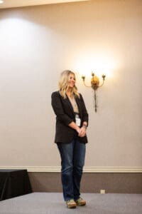 Person standing on stage with wall sconce.