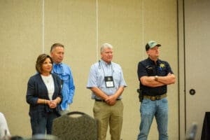 Four people standing in a conference room.