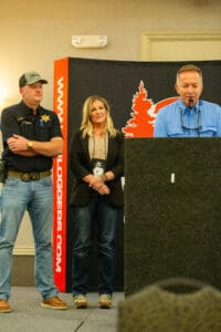 Three people standing at a podium event.