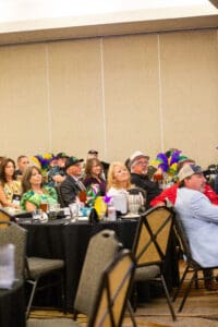 Audience seated at decorated event tables.