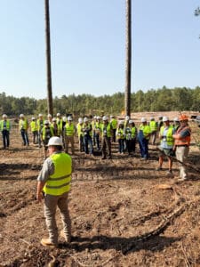 Group of people in safety vests outdoors.