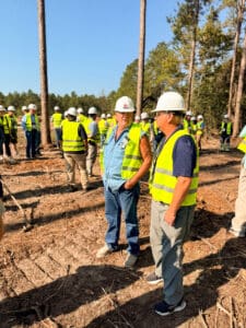Workers in safety vests and helmets outdoors.