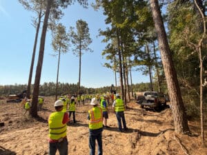 Survey crew meeting in forest clearing