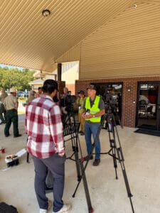 People setting up cameras outside a building.