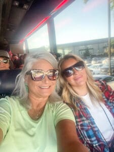 Two women smiling on a bus.