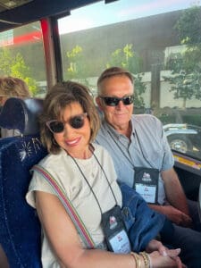 Smiling couple with lanyards seated on bus