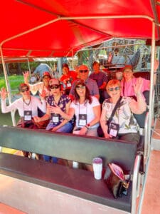 Group waving on a covered tour vehicle.