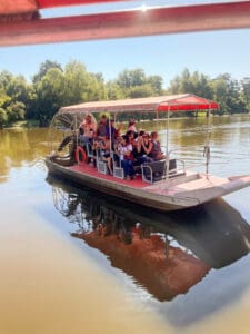 Group on airboat tour in sunny river.
