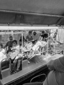 People sitting on a boat, river view.