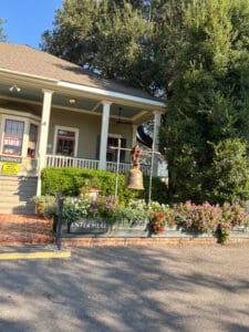 House entrance with bell and flowers outside.